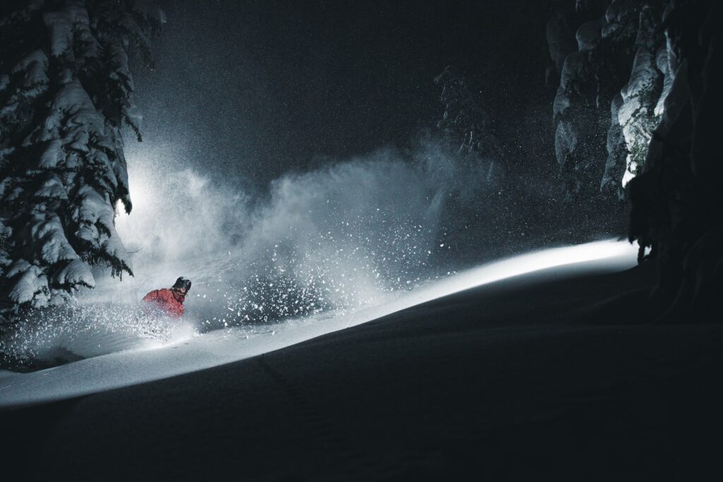 Skier skiing through snow at night at Stevens Pass