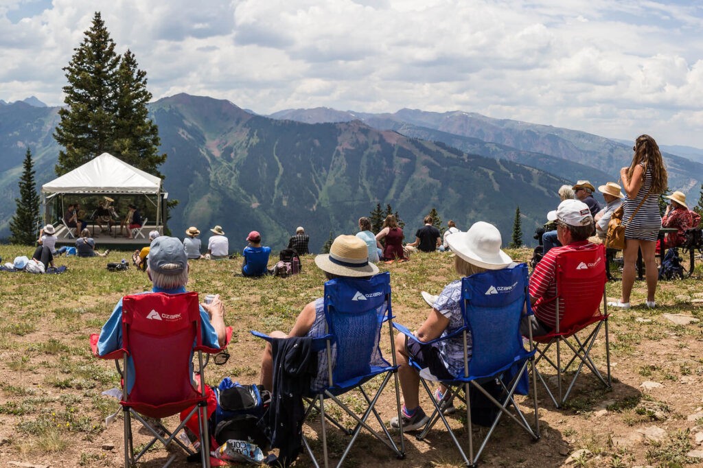 group of people sitting in chairs listening to music on Aspen Mountain